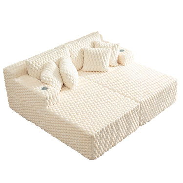 A white couch with a textured surface and several pillows