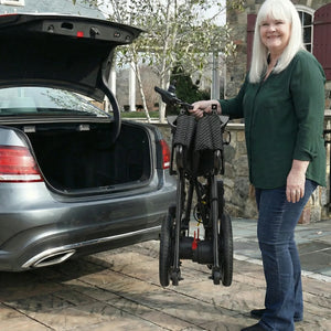 Woman with a stroller standing next to an open car trunk outdoors.